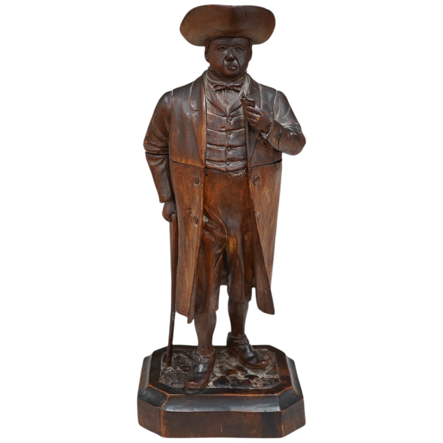 A 19th century Black Forest figure of a gentleman smoking a pipe, hinged at the waist to hold tobacco?, 36.5cm high. Condition - poor to fair, the shaft of his pipe is missing and the rear section of his hat